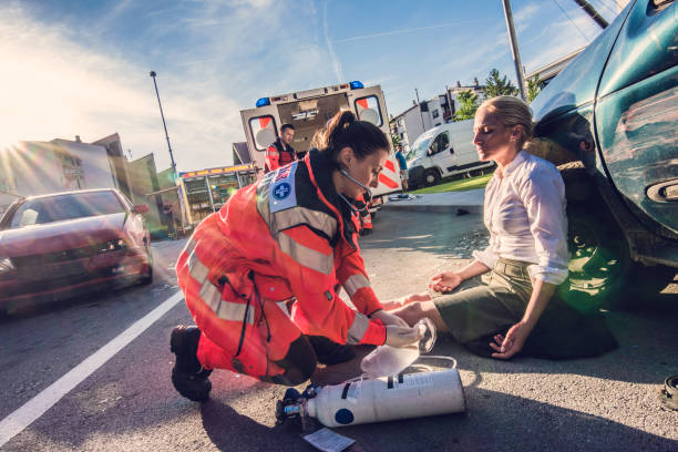 Medico femminile che fornisce il primo soccorso alla donna ferita in un incidente d'auto.